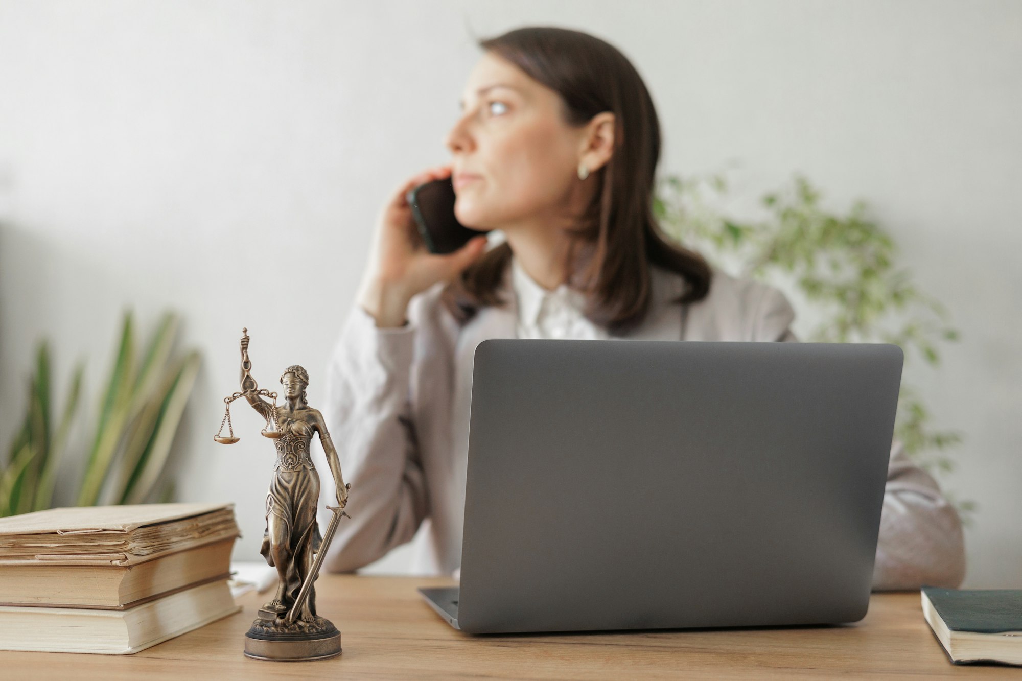 female lawyer checks a legal contract. the lawyer talks to clients by phone